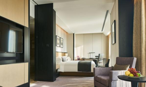 A VIP Legacy Suite with a king bed, lounge chair and work area
